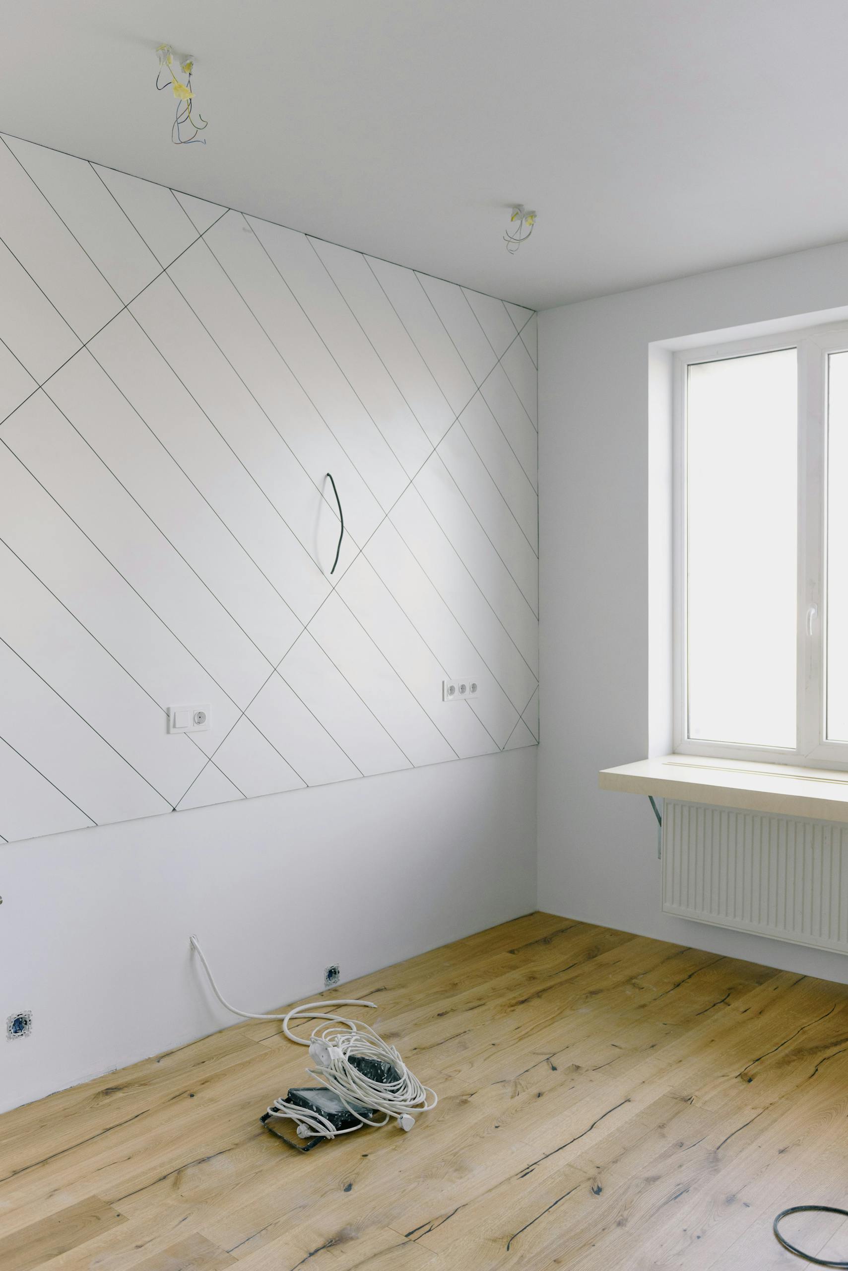 Electrical and installation work in light empty room with big window and new design